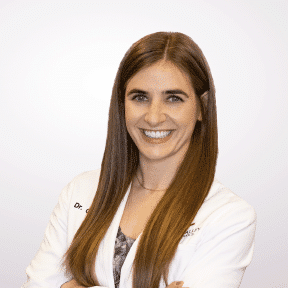 Orthodontist Dr. George, a smiling with arms crossed in a white coat at the Escondido Location.